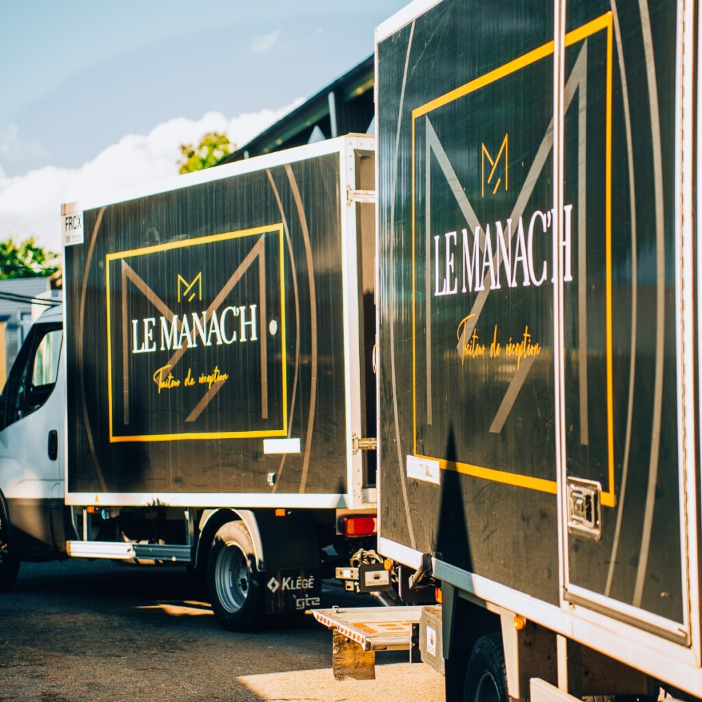 Photo de deux camions frigorifiques de l'entreprise Traiteur Le Manac'h lors d'un évènement.